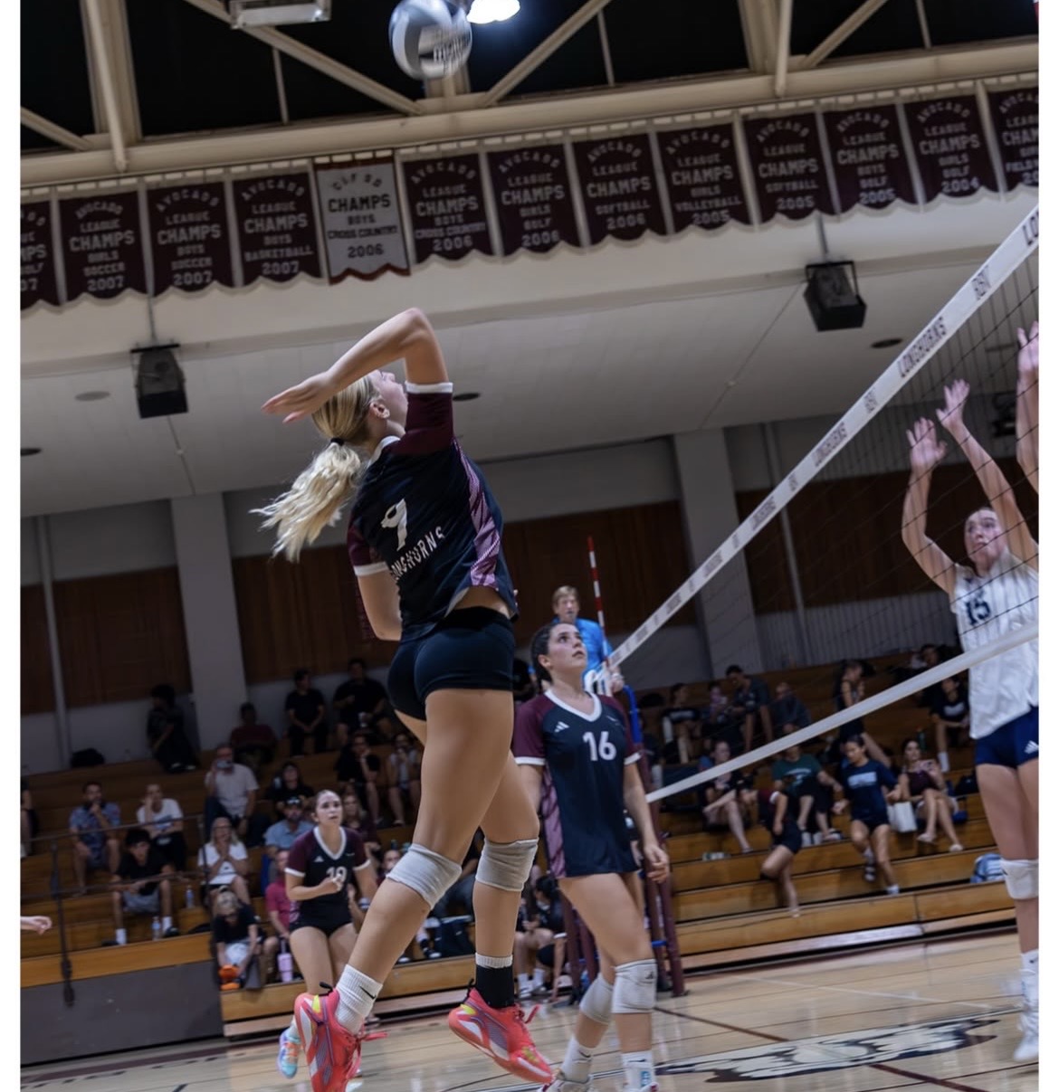 RBV varsity volleyball player attacking at the net during the LCC match